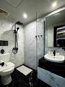 a bathroom with a toilet and a sink and a shower at Amandalu at Orchard apartemen in Lontar
