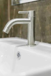 a sink with a silver faucet in a bathroom at pool villa with warm water in Ban Mae Kon