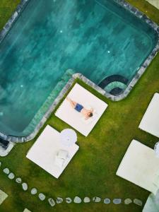 eine Aussicht auf einen Pool mit einem Mann im Wasser in der Unterkunft Dream CoWork Hotel in Kuta Lombok