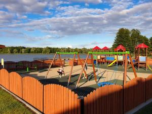 un parque con parque infantil con equipo de juegos y agua en Apartament Mazury, en Kętrzyn