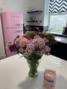 a vase of purple flowers sitting on a counter in a kitchen at No 16 Main Accommodation in Buncrana