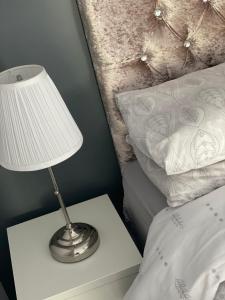 a lamp on a night stand next to a bed at No 16 Main Accommodation in Buncrana