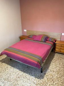 1 cama en un dormitorio con manta rosa y mesita de noche en Casa Rural Piñuecar - Sierra Norte, en Piñuécar