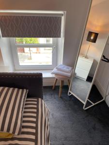 a bedroom with a mirror and a bed and a chair at No 16 Main Accommodation in Buncrana