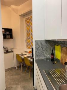 a kitchen with a counter and a table with yellow chairs at a due passi da San Pietro in Rome