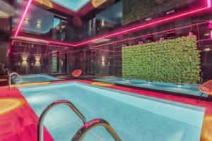 a hot tub in a room with pink lights at Royal Plater in Łeba
