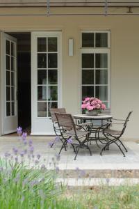 a patio with a table and two chairs and flowers at Villa Nußbaumer - Business-und Ferienwohnung in bester Lage in Arnstadt