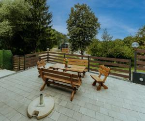 a picnic table and two benches on a patio at Vista Lago,Orahovica jezero in Duzluk