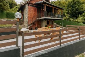 une clôture en bois devant une maison dans l'établissement Vista Lago,Orahovica jezero, à Duzluk