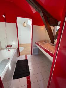 La salle de bains rouge est pourvue d'une baignoire et d'un lavabo. dans l'établissement Grand Appartement Hypercentre avec Terrasse et Parking, à Poitiers
