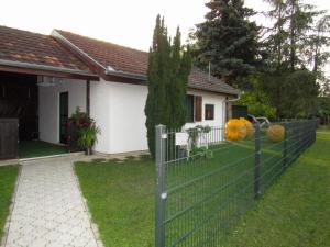 a fence with two frisbees on it in front of a house at OBALA apartman in Subotica