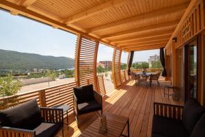a large wooden deck with chairs and tables on it at Camp Ante-Gojko in Grebaštica