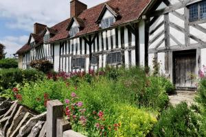 ein altes Haus mit Garten davor in der Unterkunft The Mary Arden Inn in Stratford-upon-Avon