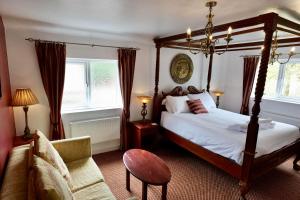 a bedroom with a canopy bed and a couch at The Mary Arden Inn in Stratford-upon-Avon