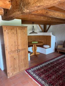 Charming alps apartment perfect for walk/cycle/ski في Eschenbach: غرفة مع طاولة وخزانة وسجادة