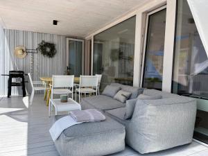a living room with a couch and chairs on a porch at BUQEZ ECO RESORT - Beach Villas 2 and 8 - Seaview, new wifi! in Drage