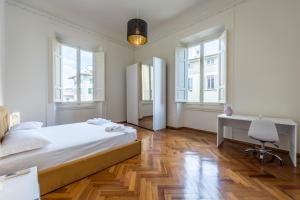 - une chambre avec un lit, un bureau et des fenêtres dans l'établissement [5 min Duomo] Magnificent Home, à Florence