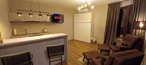 a room with a bar with chairs and a kitchen at LIKE HOME 3 CENTRUM RYNEK in Świdnica