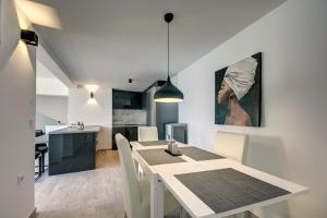 een eetkamer en een keuken met een tafel en stoelen bij Sea Wave Apartment in Kruče