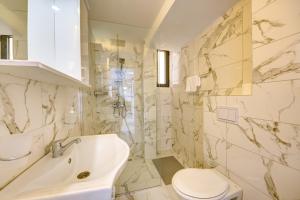 een witte badkamer met een wastafel en een toilet bij Sea Wave Apartment in Kruče