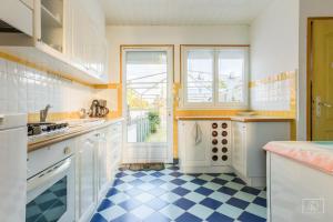 uma cozinha com armários brancos e um piso xadrez azul e branco em maison jardin terrasse em Le Tréport