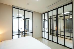Schlafzimmer mit großen Glasfenstern und einem Bett in der Unterkunft Pyeongchang The White Hotel in Pyeongchang