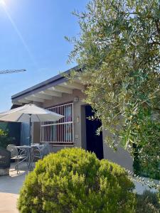 a house with a table and an umbrella at Case vacanza le vele in Desenzano del Garda