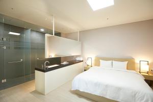 1 dormitorio con cama, lavabo y ducha en Pyeongchang The White Hotel en Pyeongchang 