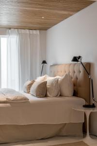 een slaapkamer met een bed met witte kussens en een raam bij Deluxe House With Private Sauna at Kamppi in Helsinki