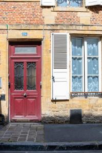 a red door and windows on a brick building at Appartement Meuse & Mono, en hyper centre in Charleville-Mézières