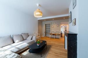 a living room with a couch and a table at Appartement Meuse & Mono, en hyper centre in Charleville-Mézières