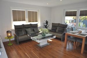 a living room with a couch and a table at Ferienwohnung Deichland 65351 in Moormerland