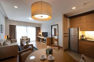 a kitchen and living room with a table and a living room at Kantary Hotel Kabinburi in Kabin Buri