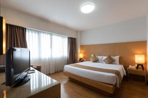 a hotel room with a bed and a flat screen tv at Kantary Hotel Kabinburi in Kabin Buri