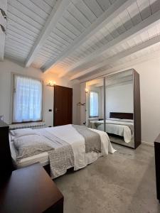 una camera con un grande letto e un grande specchio di Case vacanza le vele a Desenzano del Garda