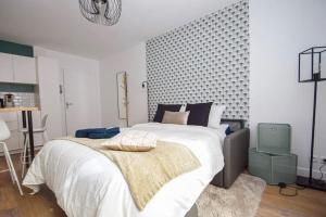 a bedroom with a large bed with white sheets and blue pillows at Charmant 2P centre ville Orléans in Orléans