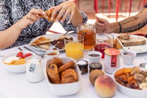 a group of people sitting at a table with breakfast foods at Villa Sainte Anne in Porquerolles