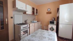 a small kitchen with a stove and a refrigerator at Apartmán Vika in Štrba