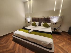 - une chambre dotée d'un grand lit avec des oreillers verts et blancs dans l'établissement Express Square9, à Gurgaon