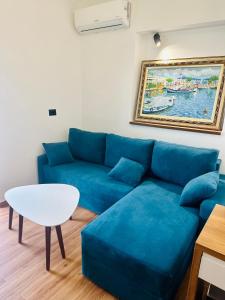 ein Wohnzimmer mit einem blauen Sofa und einem Tisch in der Unterkunft ILLYRIAN hotel in Ksamil