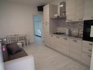 cocina con fregadero y fogones horno superior en Condominio Belletti, en Lignano Sabbiadoro