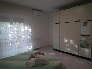 - une chambre avec un lit et des armoires blanches dans l'établissement Condominio Belletti, à Lignano Sabbiadoro