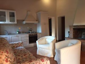 a living room with a couch and chairs in a kitchen at Agriturismo il Canneto in Casole dʼElsa +2 photos