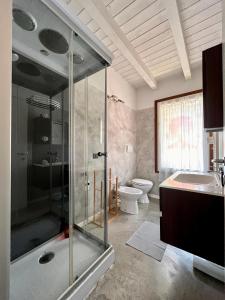 bagno con doccia in vetro e servizi igienici di Case vacanza le vele a Desenzano del Garda