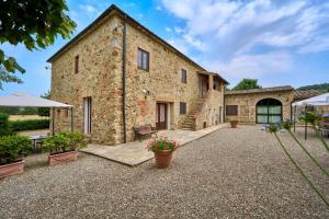 an exterior view of a stone building with a patio at Agriturismo il Canneto in Casole dʼElsa