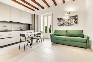 een woonkamer met een groene bank en een tafel bij Alessia's Flat- Naviglio Grande in Buccinasco