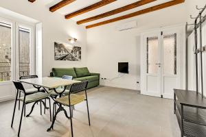 sala de estar con mesa, sillas y sofá en Alessia's Flat- Naviglio Grande en Buccinasco