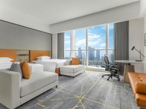 広州市にあるSheraton Guangzhou Hotelのベッド2台とデスクが備わるホテルルームです。