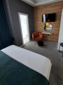 1 dormitorio con 1 cama, 1 silla y TV en A8 b&b, en Zagreb