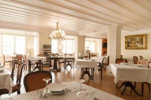 a restaurant with white tables and chairs and a chandelier at Hotel Joao Padeiro in Aveiro